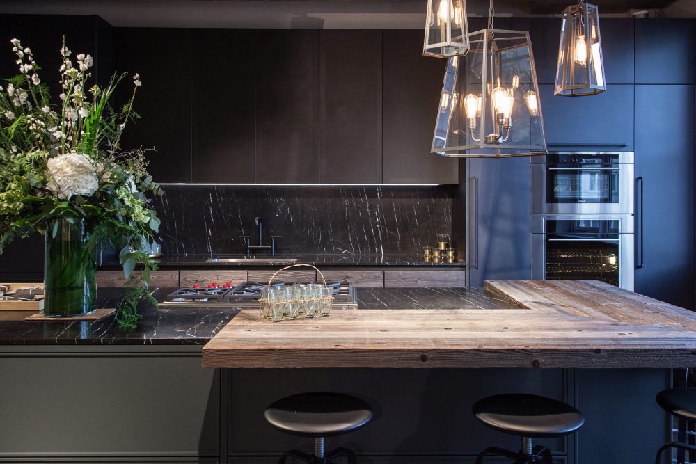 Modern kitchen design featuring black marble and unfinished wood for doors countertop