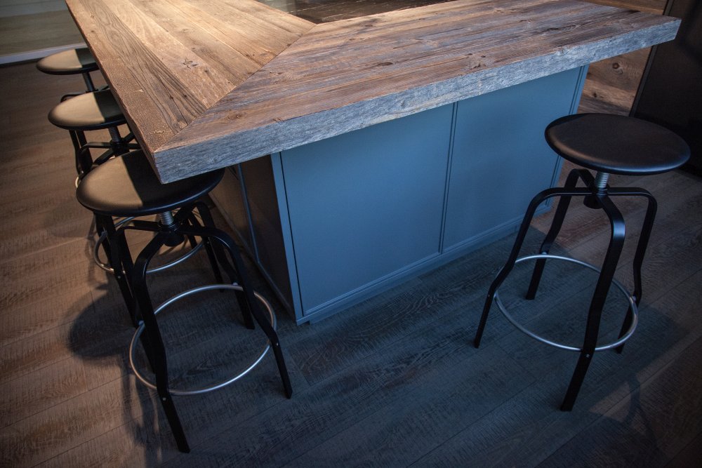 Modern kitchen design featuring black marble and unfinished wood for doors stools