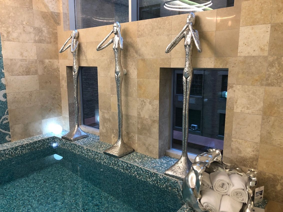 Modern silver sculptures add drama and whimsy to the pool space.