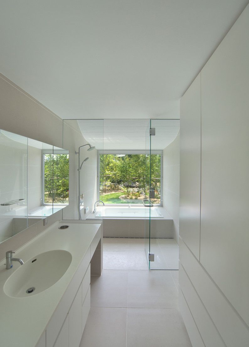 Narrow bathroom with white walls and large vanity sink