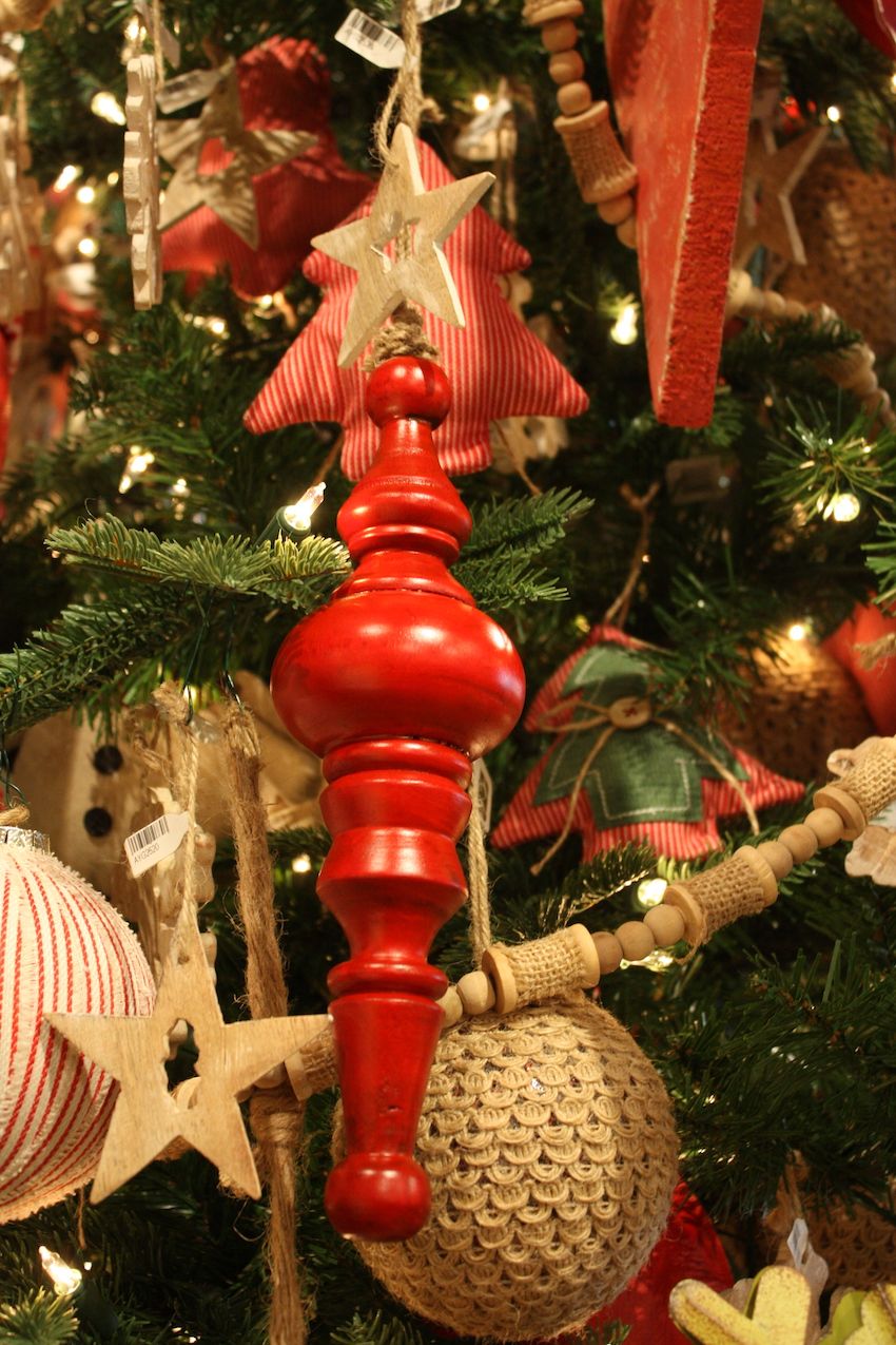 Natural wood, burlap and other textiles add an earthy feeling to the red decorations.