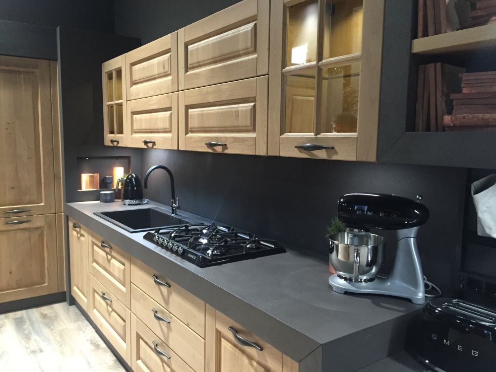 Natural wood molded kitchen cabinets with black counter top