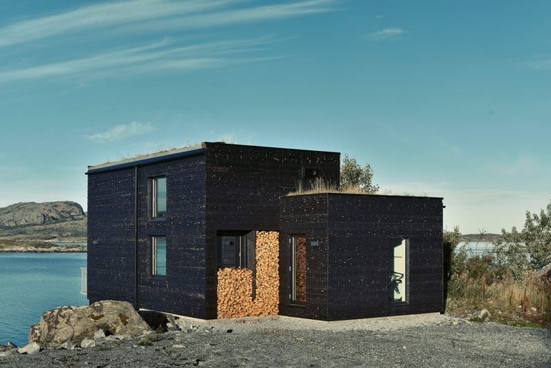 Norway black cabin with wood log storage