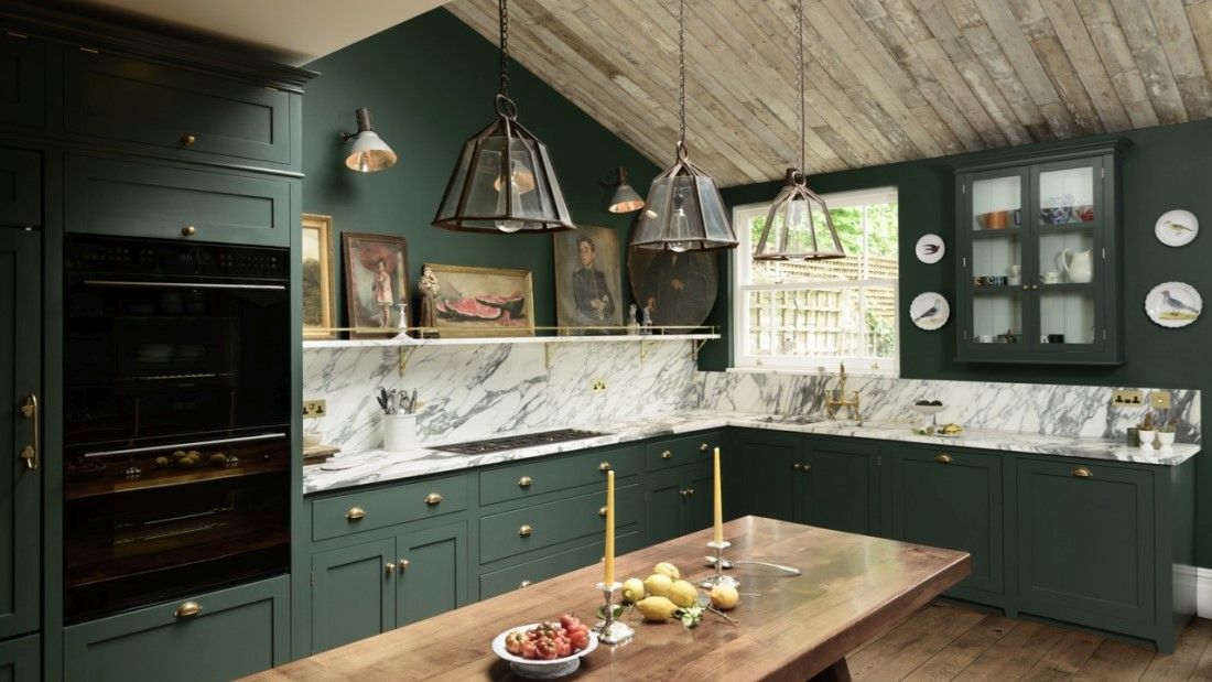 Opulent green kitchen with marble countertop and backsplash