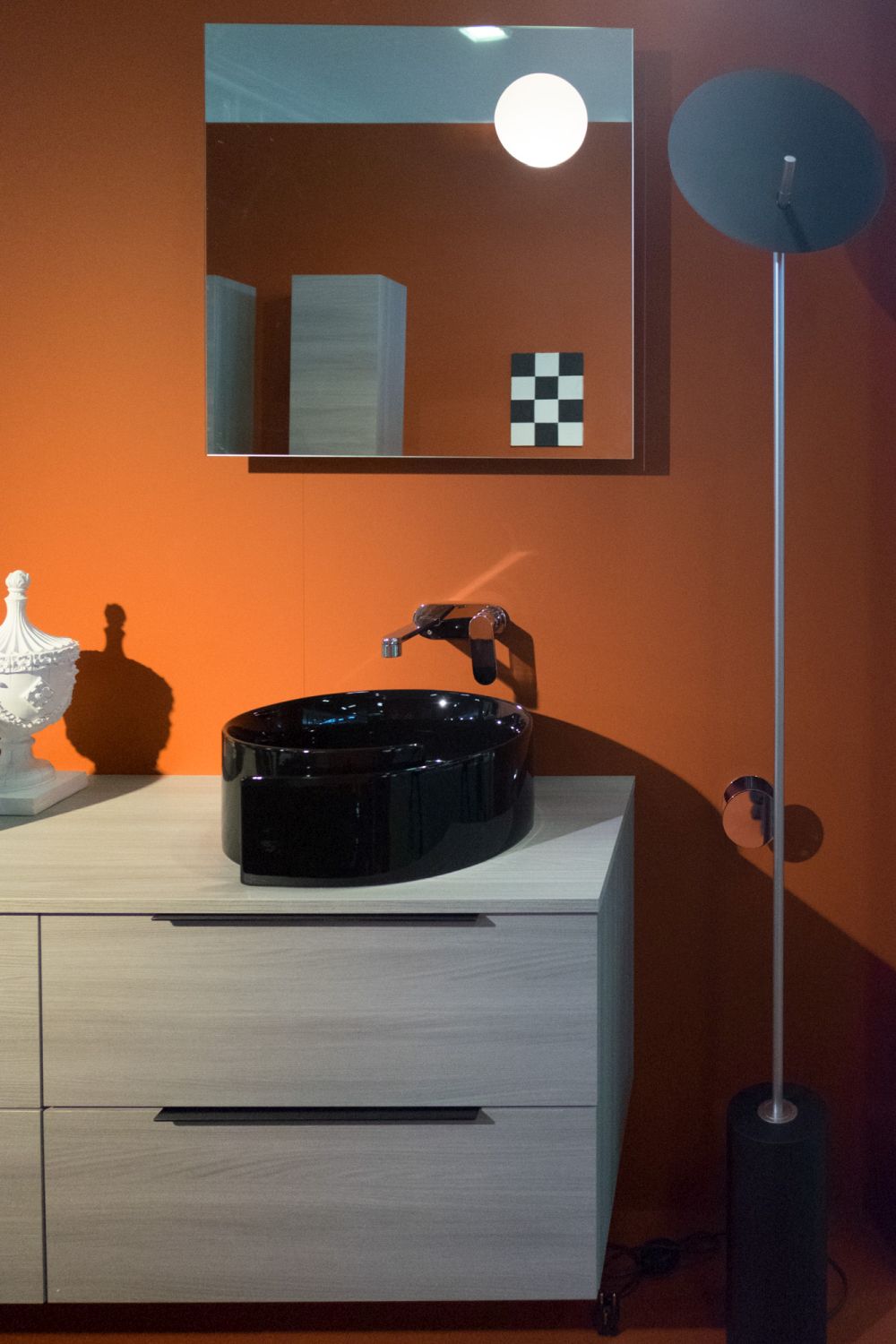 Orange wall with black round wash basin