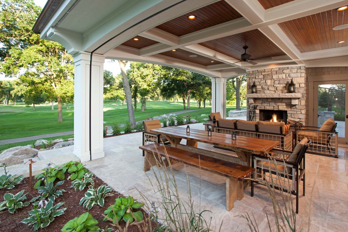 Outdoor living area with fireplace and roll up screens