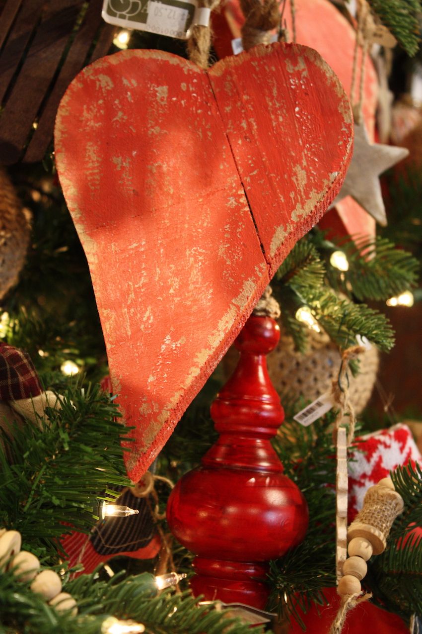 The rough-hewn heart is a casual contrast to the bright, painted wooden ornaments.