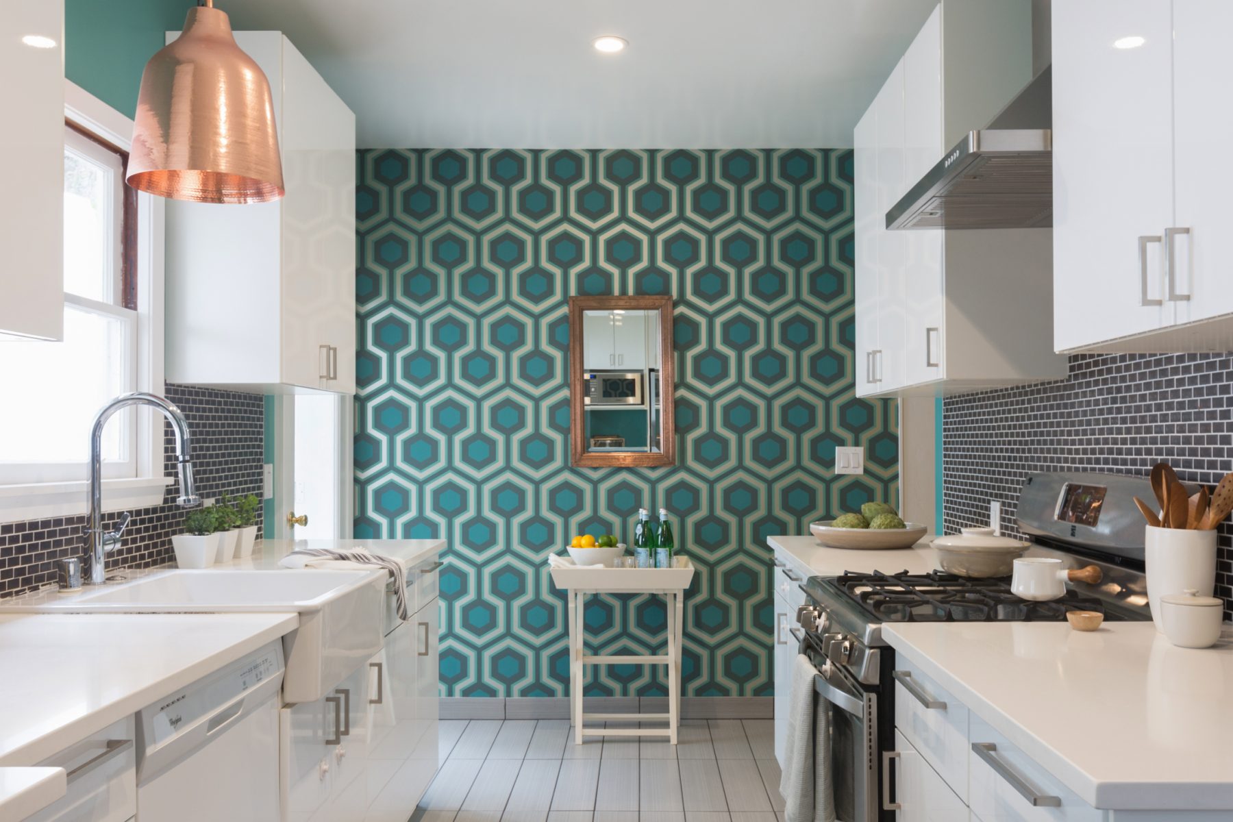 Teal wallpaper at the end of a kitchen.