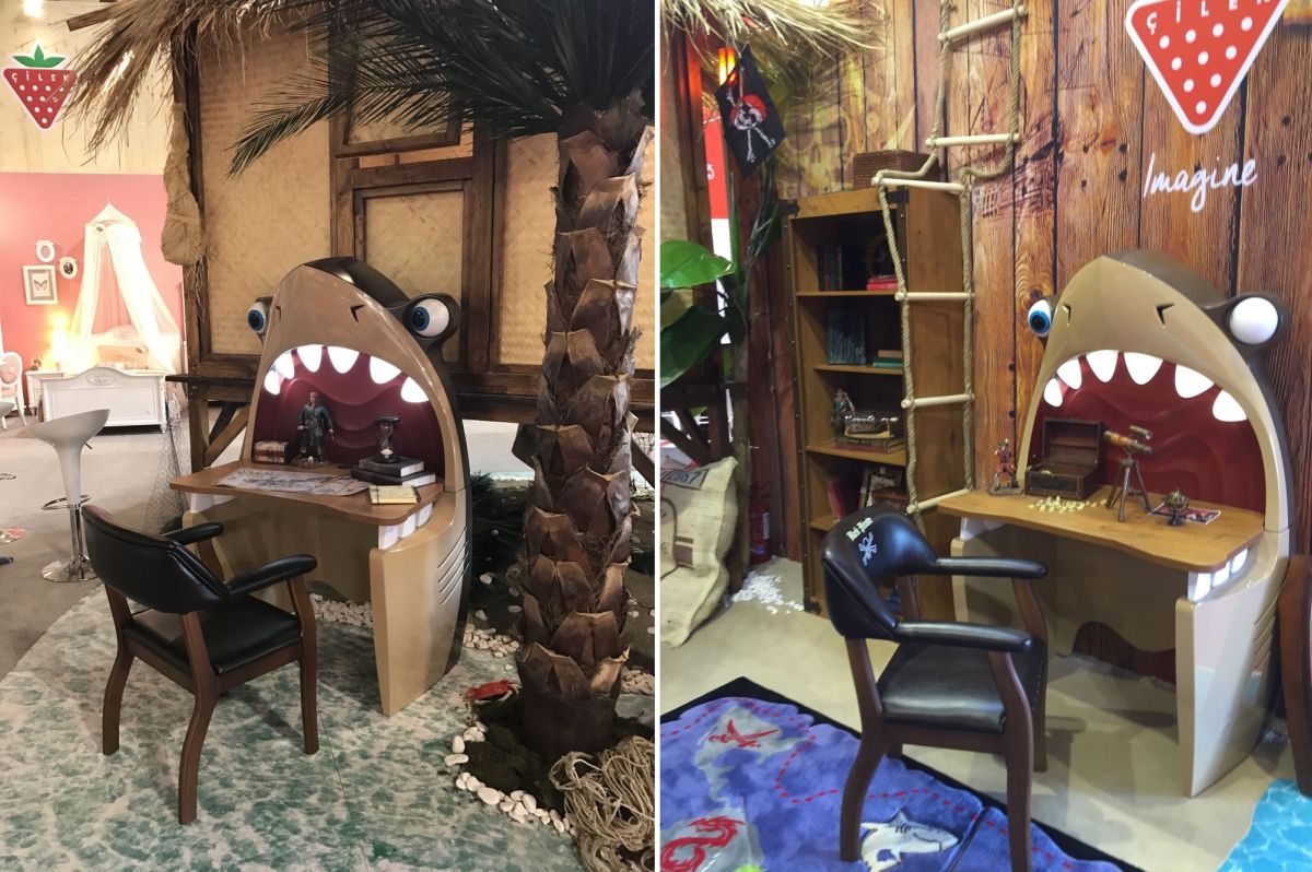 The desk is shaped like a great shark that appears to take a bite out of the top like it were a surfboard