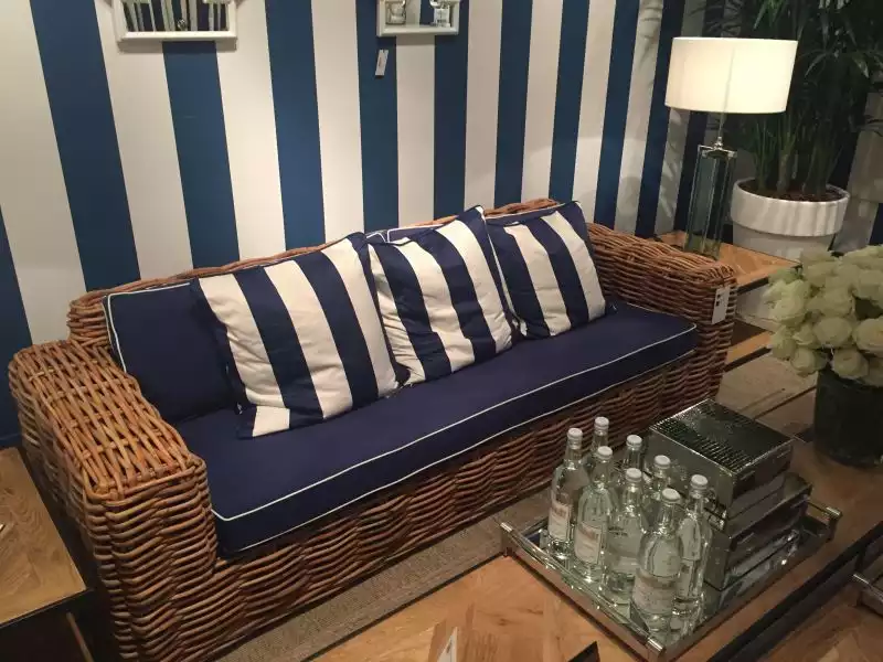 rattan-outdoor-couch-with-striped-blue-and-white-pillows