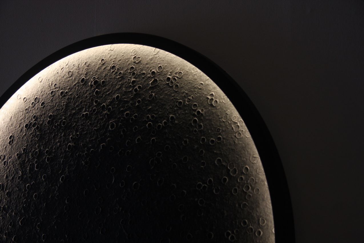 Hidden light sources push light into the center of the circle, reflecting off irregularities in the hand made paper.