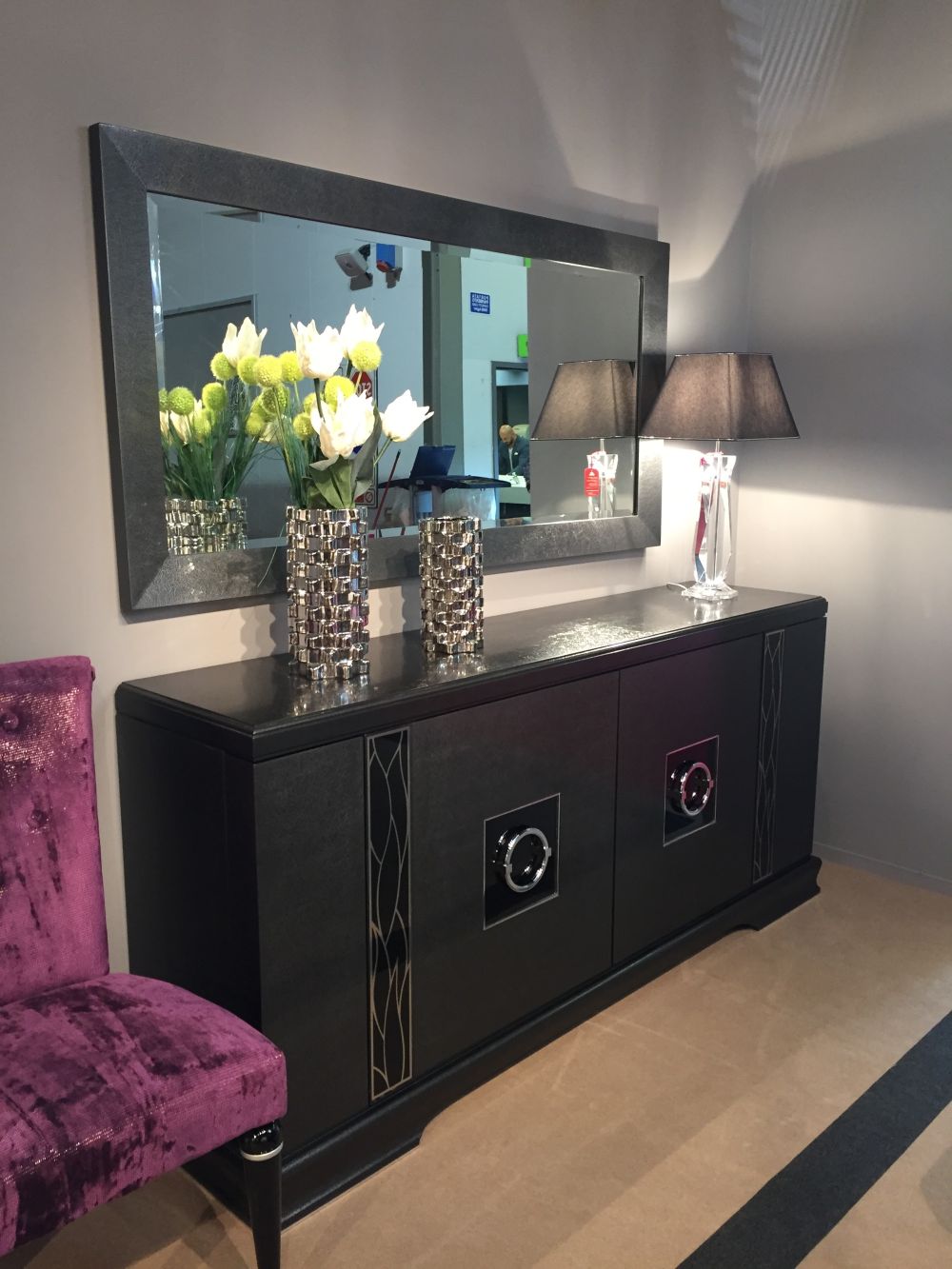 Rectangular decorative mirror above the entryway sideboard and decorated with fresh flowers
