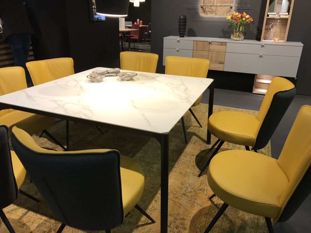 Rectangular dining table with marble on top and yellow leather dining chairs