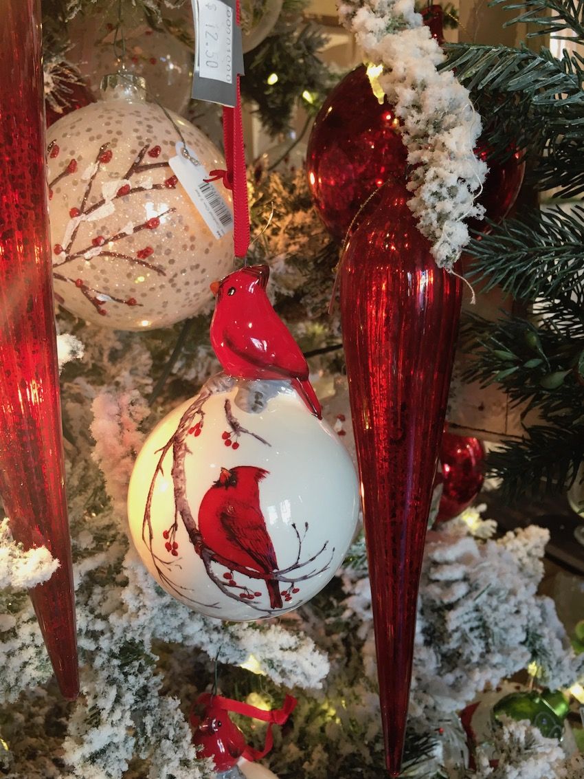 Red cardinals and berry sprigs adorn the ceramic ball ornaments.