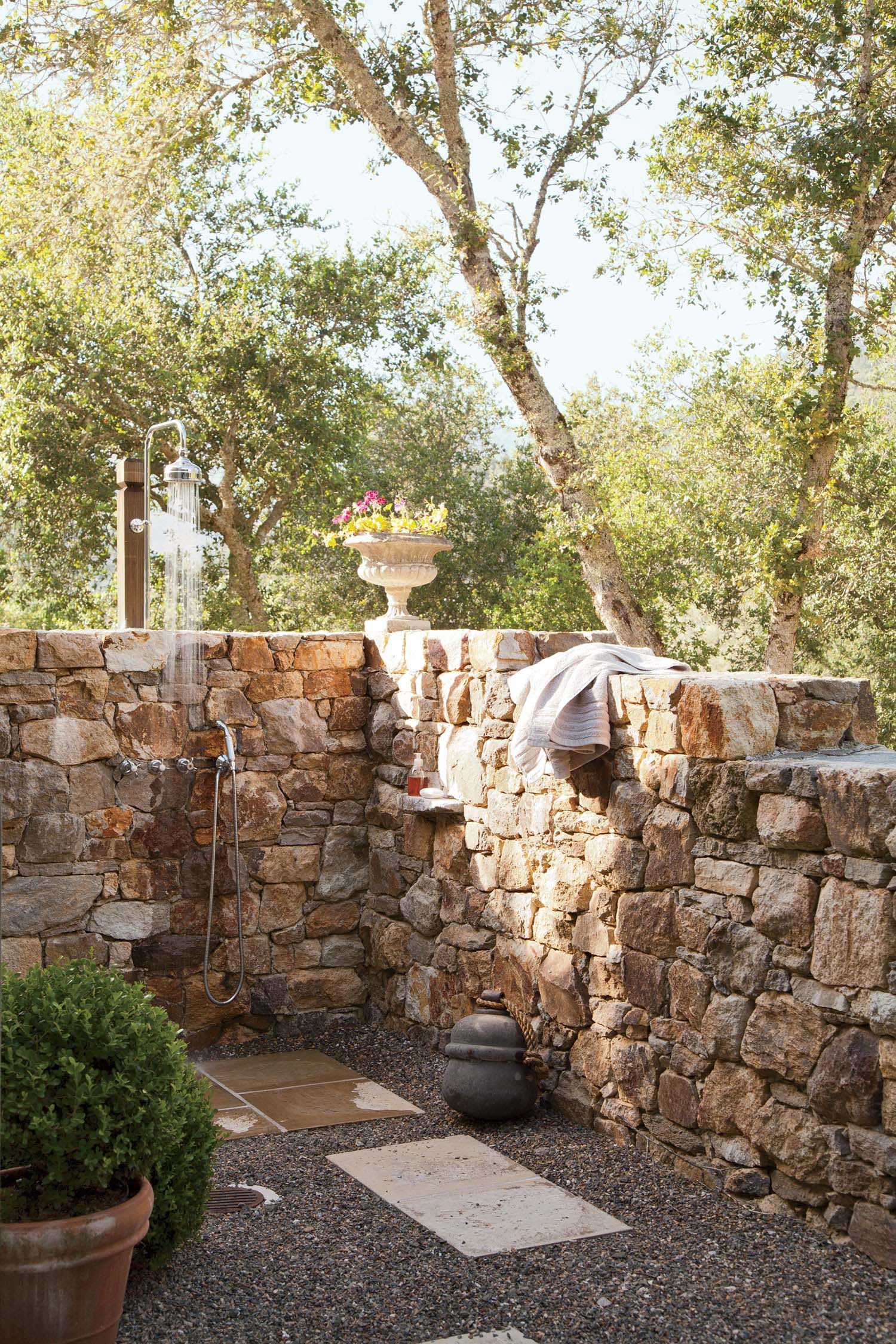 Rock wall outdoor shower design and gravel