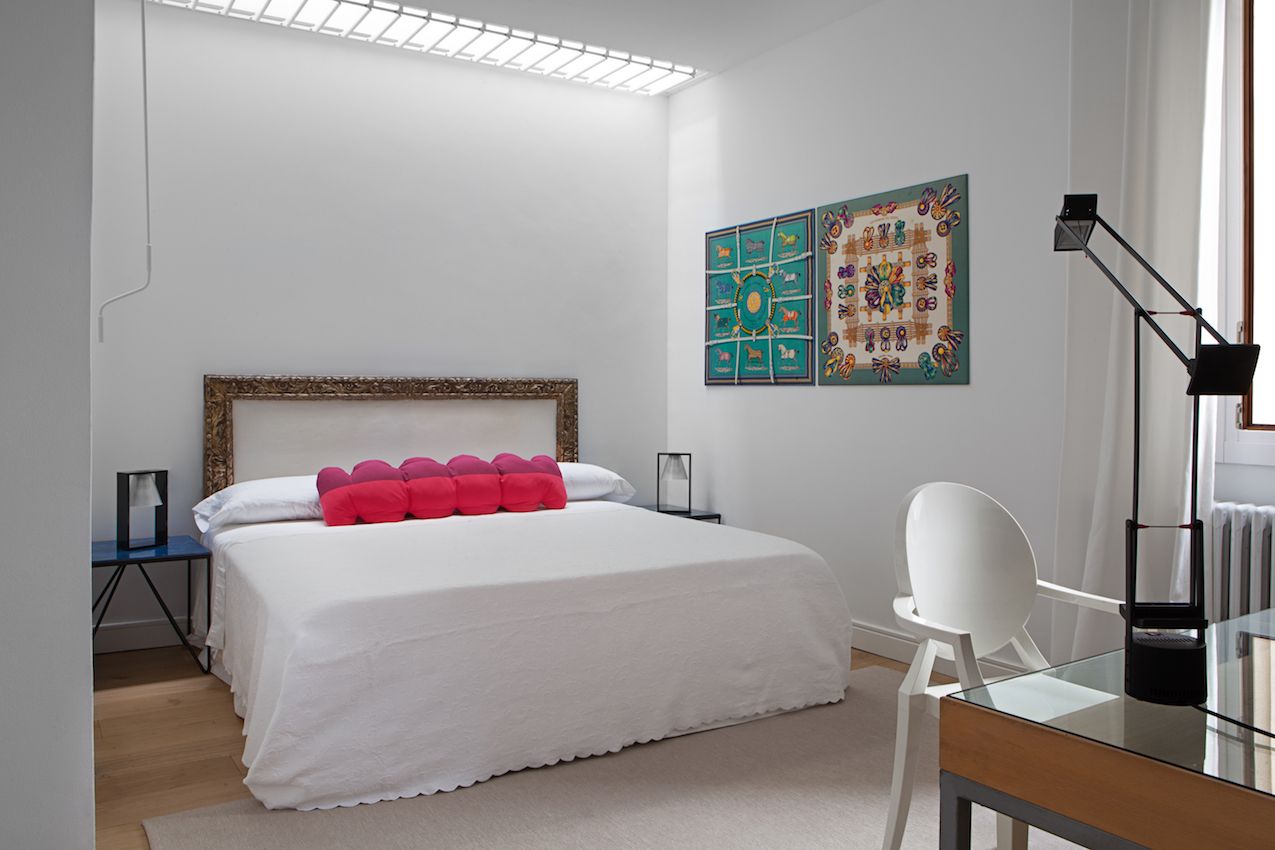 The unusual cushion provides the dominant pop of pink in this bedroom.