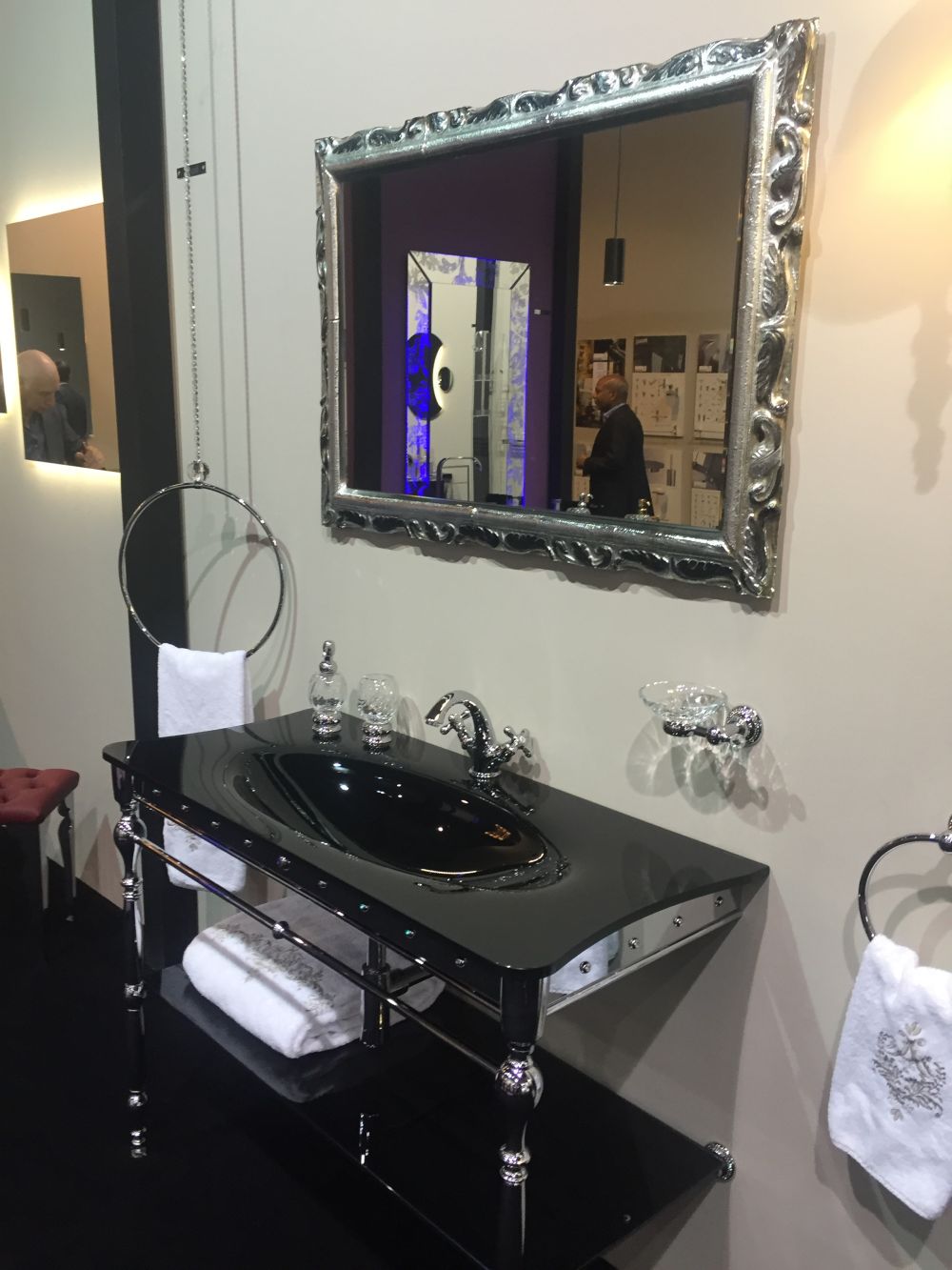 Silver mirror above the black sink vanity