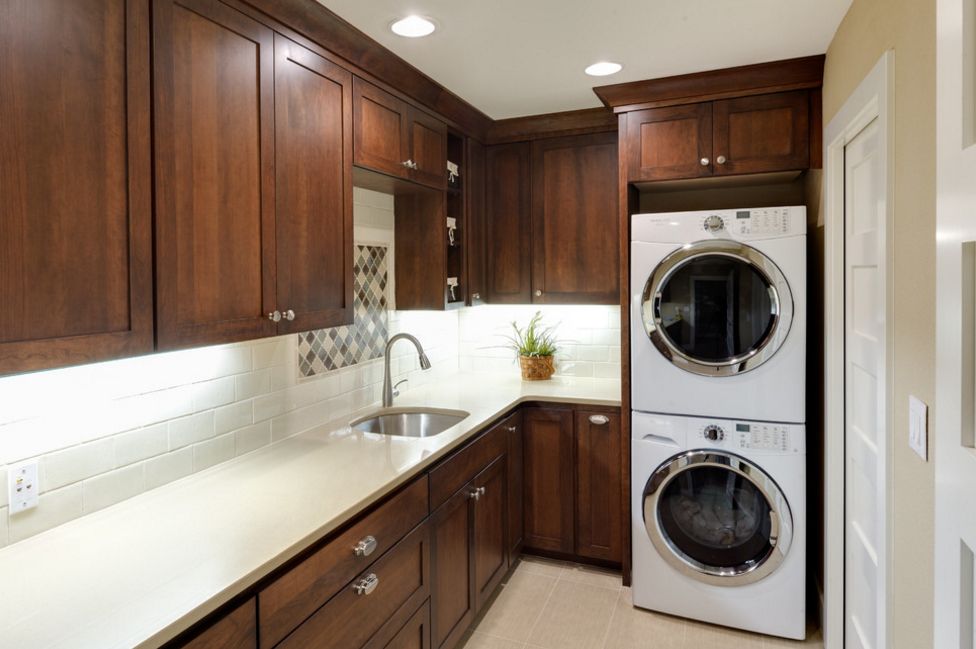 Small laundry room in darkwood and stacked washer