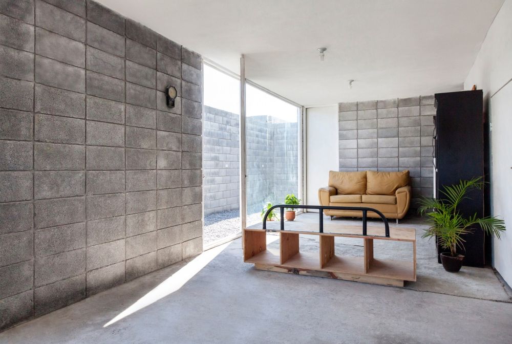 Small living room with concrete floor and raw walls