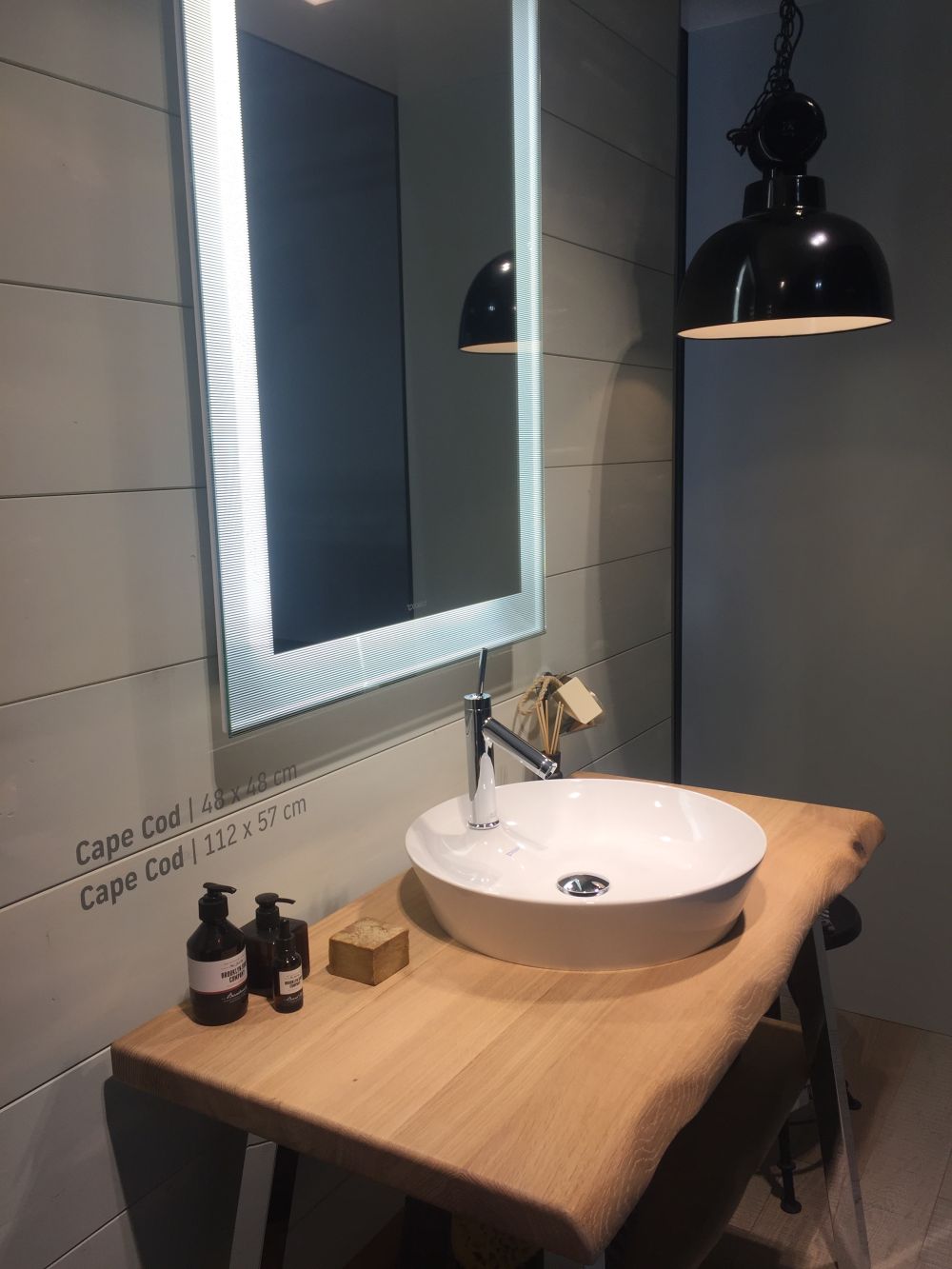 Small vessel sink and mirror with light wood countertop