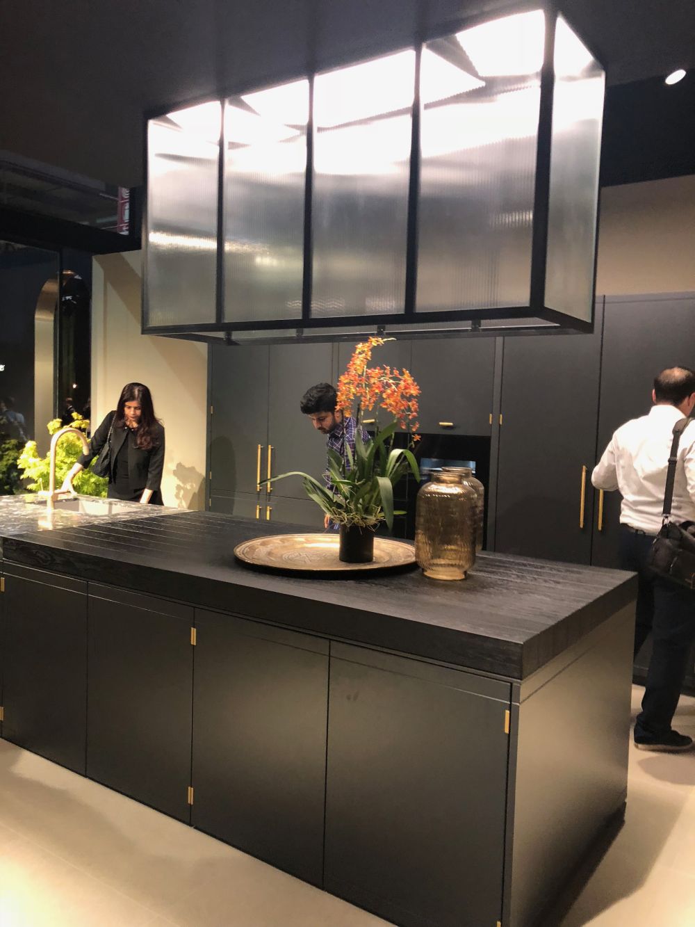 Solid dark wood kitchen countertop island and large lighting fixtures over it