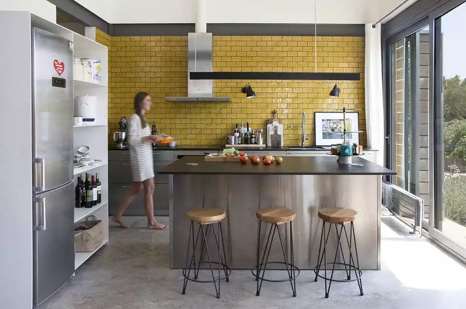 Stainless steel kitchen island and yellow subeay tiles