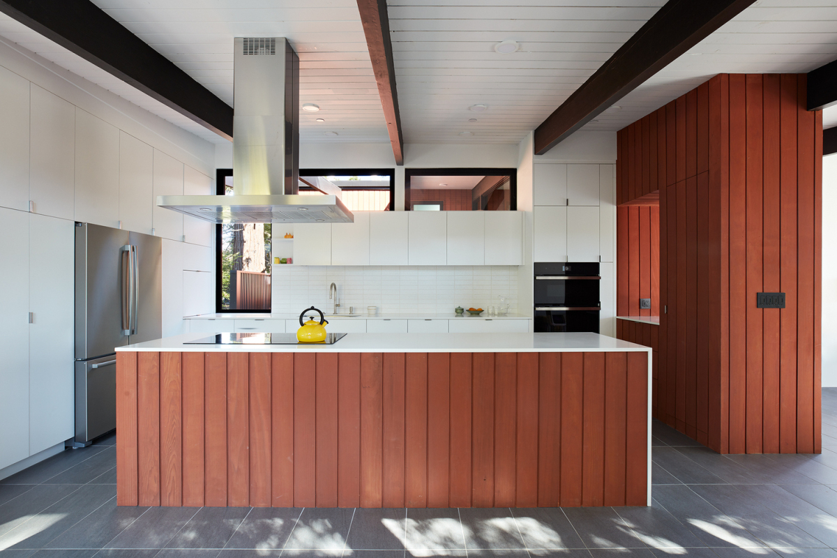 The kitchen island acts as a visual barrier and divider between the cooking area and the living spaces