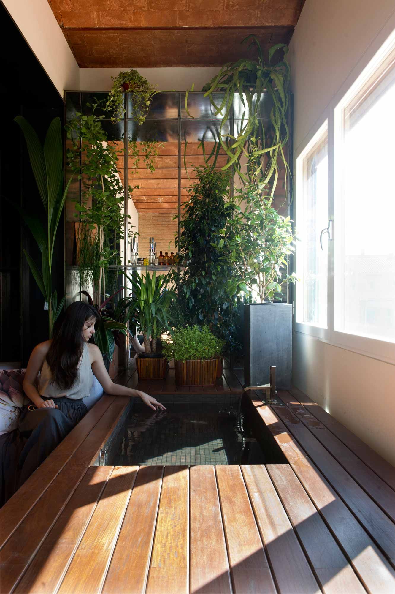 Plants are a visual barrier to the living space seen through the alcove window.