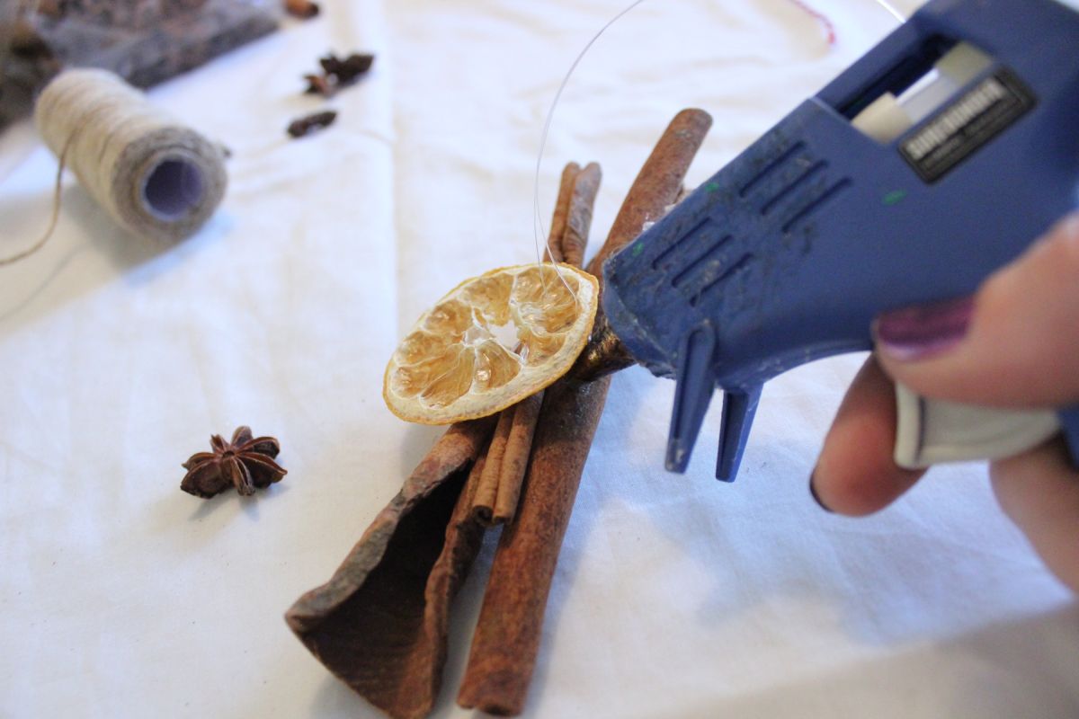 The fishing line will hold the fruit to the cinnamon sticks