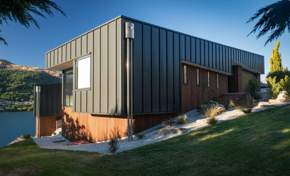 This Hillside Home With Black Metal Siding backyard