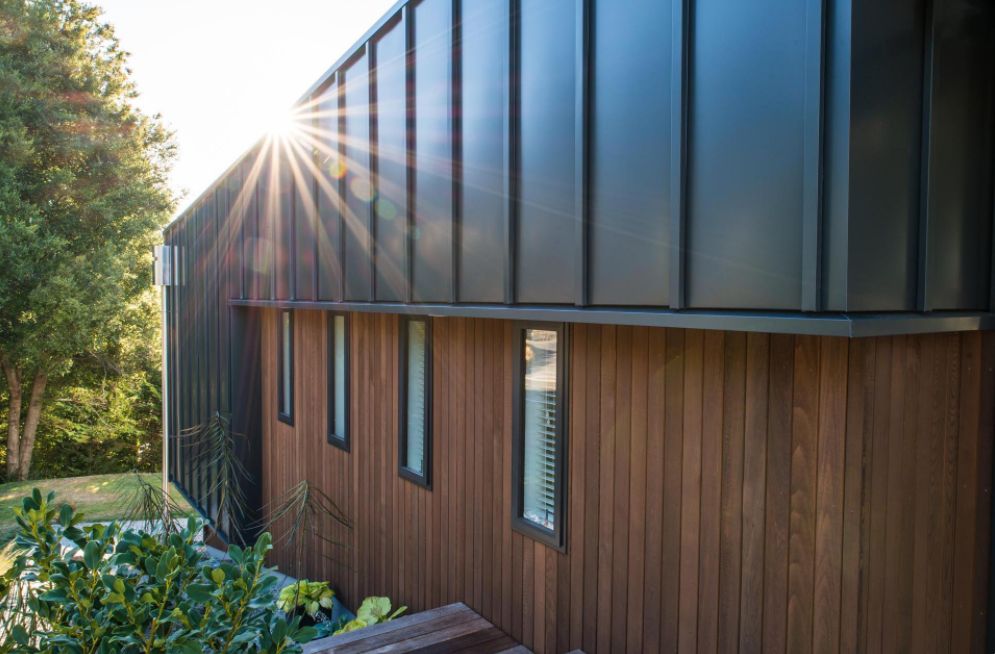 This Hillside Home With Black Metal Siding exterior