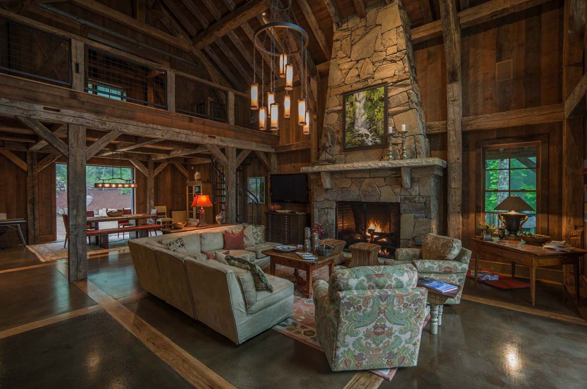 Timber frame cabin living room with a large stacked stone fireplace