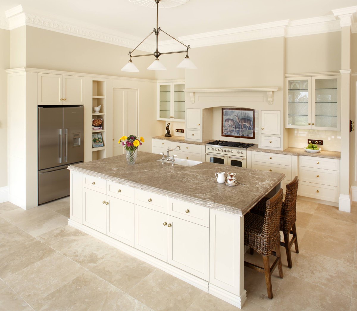 Traditional cream kitchen cabinets with island and travertine floor
