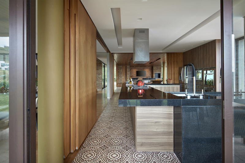 The kitchen is situated at the center of the house, being open to adjacent spaces on all four sides