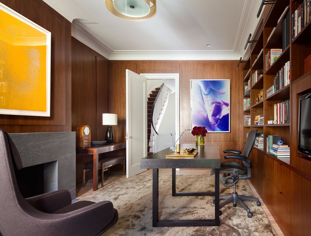 The wood walls make a serene backdrop for the homeowner's colorful artwork and the modern desk.