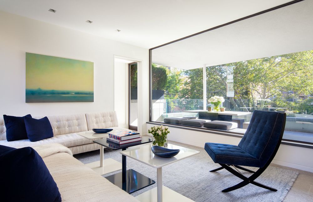 Another pop of color in the townhouse is in the living room where blue pillows and a chair, as well as the artwork planned with the view out the window.