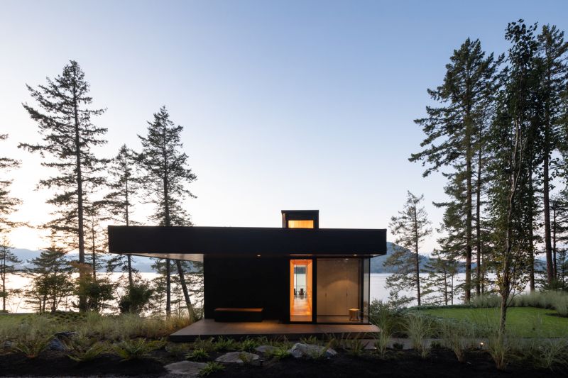 Waterfront cabin with a forest backdrop backyard