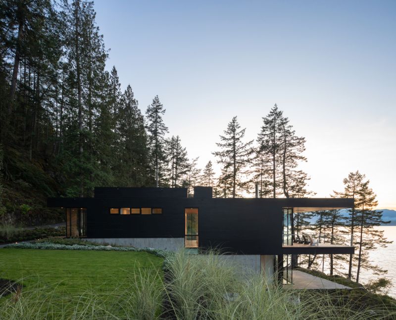 Waterfront cabin with a forest backdrop side view