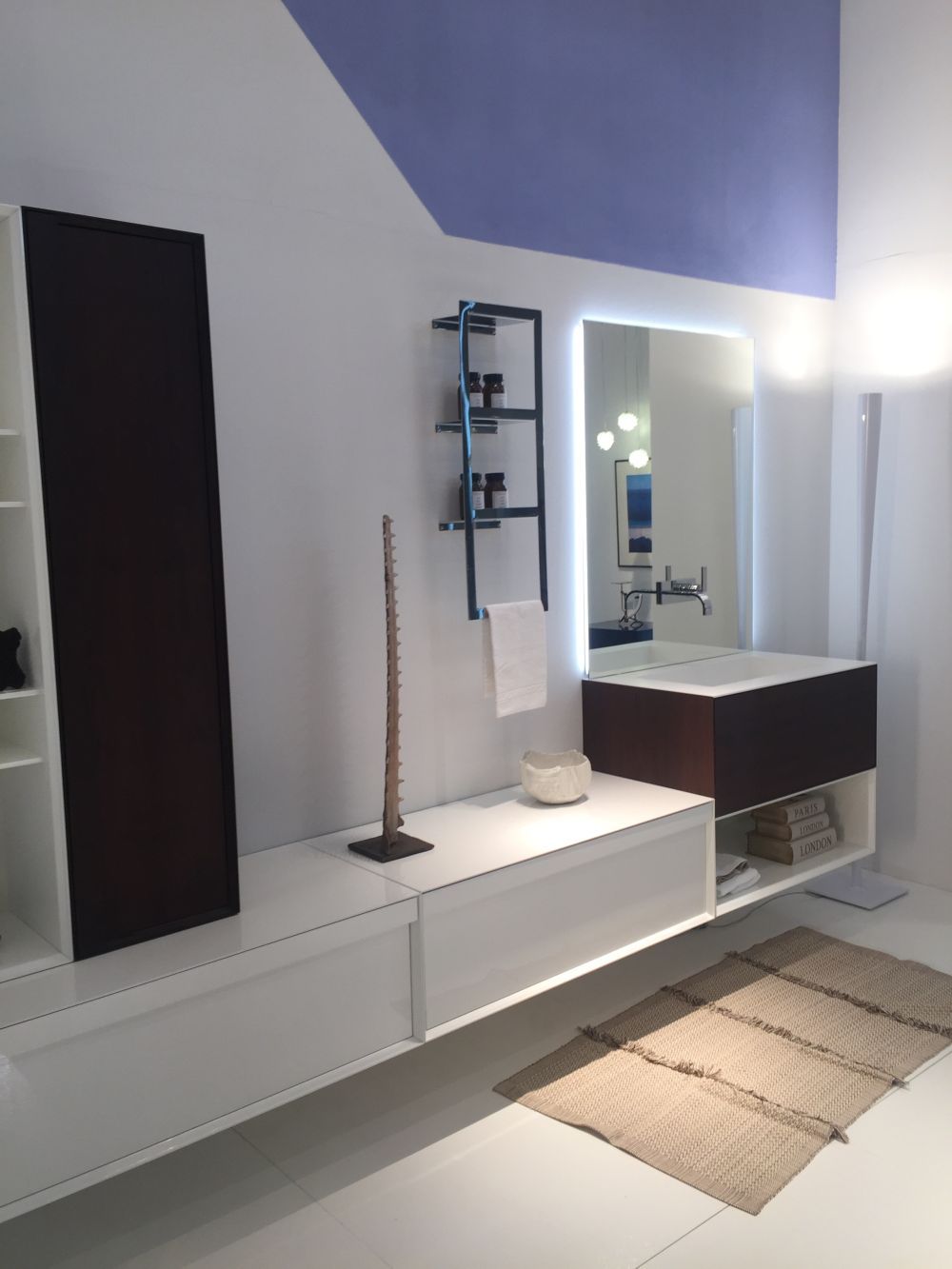 White bathroom design with a stylish and creative mirror featuring backlit