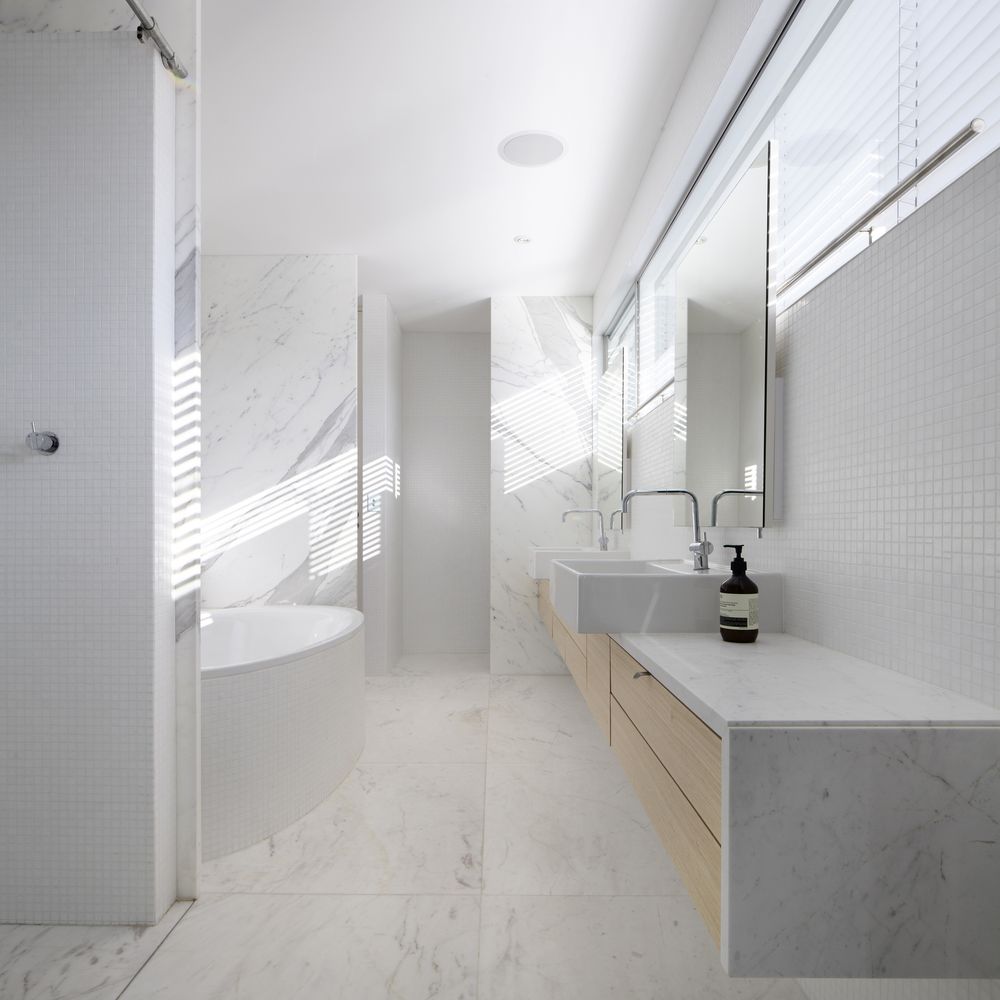 White bathroom with marble tiles and round tub