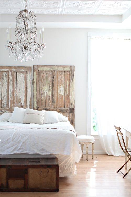 White bedroom with old doors for headboard