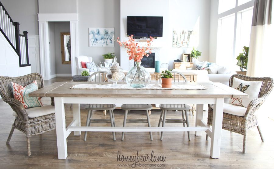 White farmhouse table with rattan chairs