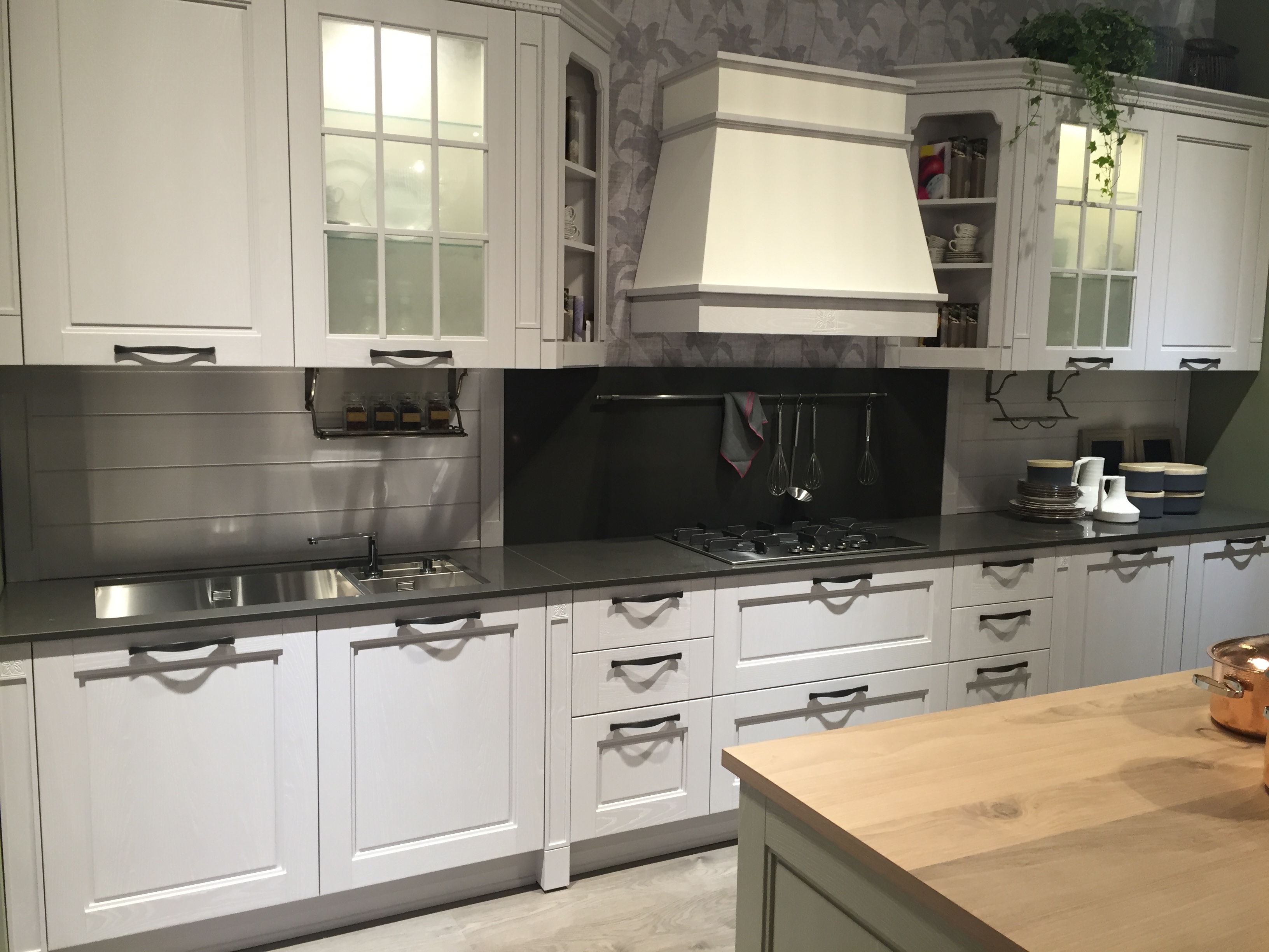 White kitchen design with frosted glass cabinets doors and black countertop