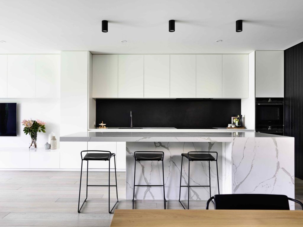 White kitchen design with marble and black countertop