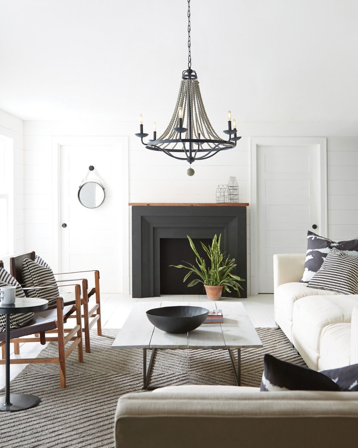 White living room with rustic accents and black chandelier decor
