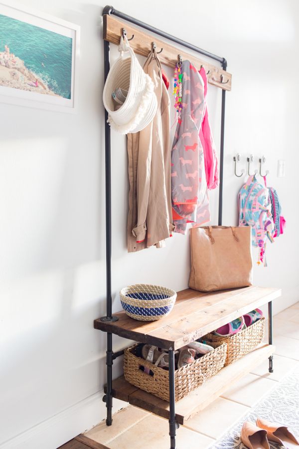 A coat rack made of wood and metal pipes