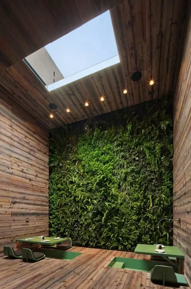 A green wall accents the Tori Tori Restaurant in Mexico City by Rojkind Arquitectos + ESRAWE Studio.