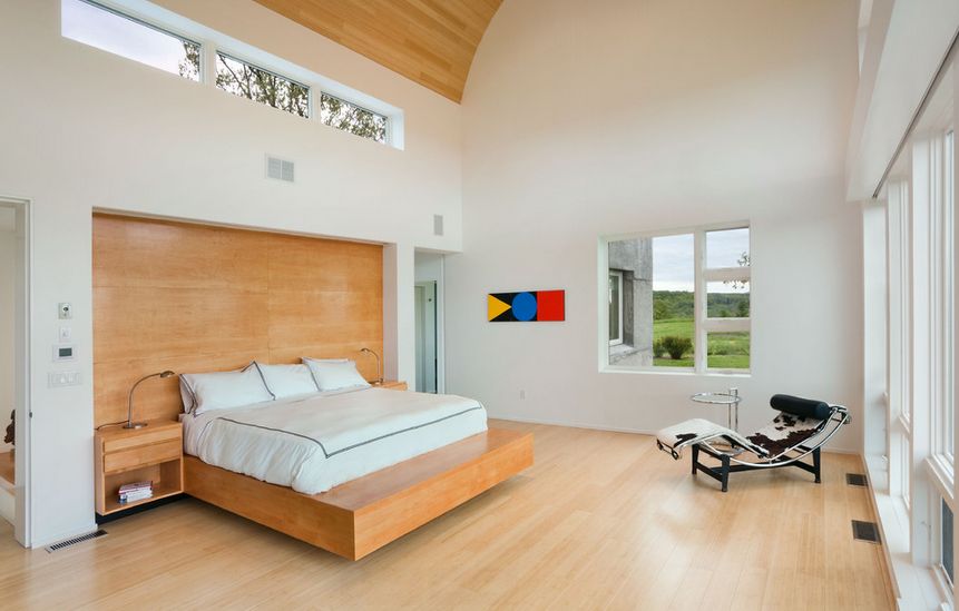 Wooden platform floating bed on a high ceiling bedroom