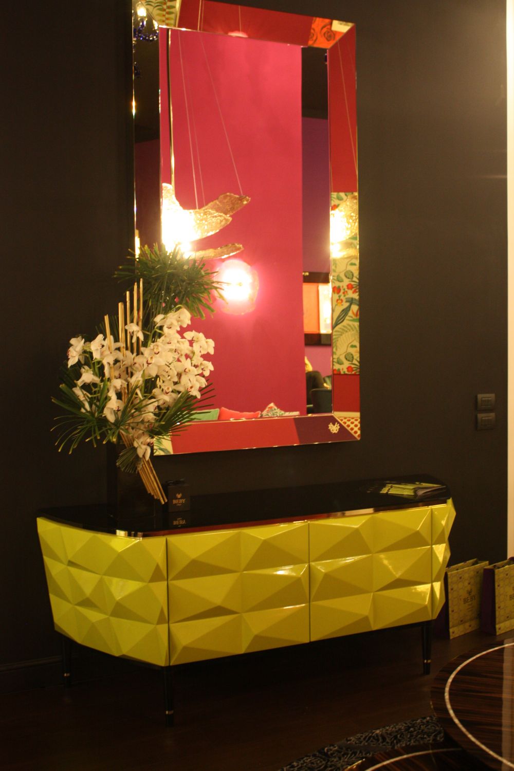 Yellow hallway cabinet with fuschia decor