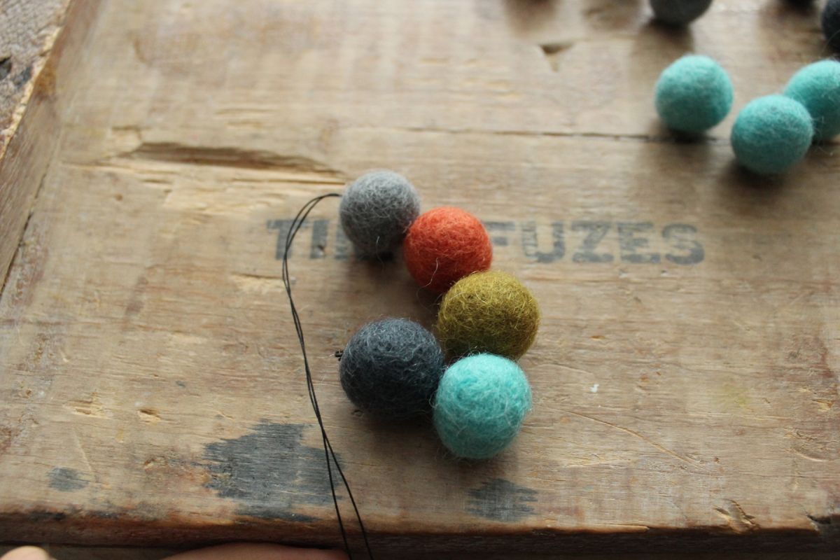 add two more felt balls onto your thread